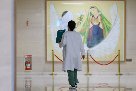 정부의 의과대학 증원 방침에 반발한 전공의들이 사직서를 내고 근무 현장을 이탈한 지 한 달이 넘은 가운데 20일 서울 시내 한 대학병원에서 의료 관계자가 이동하고 있다. [연합뉴스]